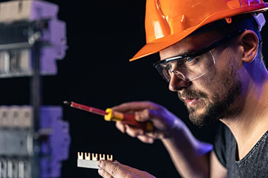 a-male-electrician-works-in-a-switchboard-with-an-electrical-connecting-cable–1024×682