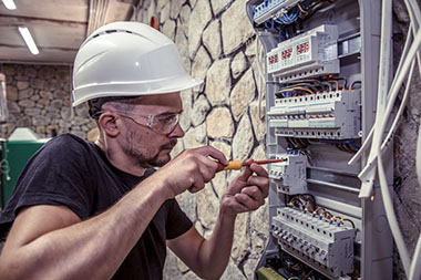 a-male-electrician-works-in-a-switchboard-with-an-electrical-connecting-cable-1024×682