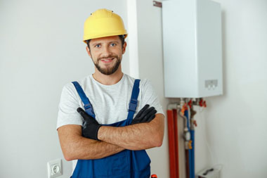 cheerful-male-worker-technician-servicing-the-house-heating-system-smiling-at-camera-while-standing-1024×682
